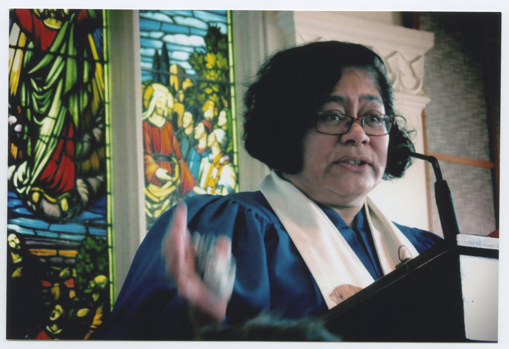 Rev. Alofa Lale in front of a stained glass window