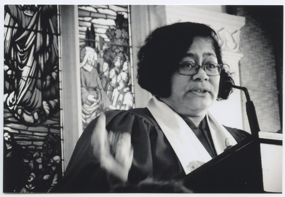 Rev. Alofa Lale in front of a stained glass window