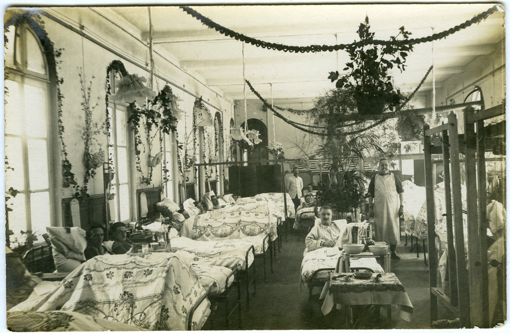 A hospital ward decorated for Christmas, with soldiers in bed 