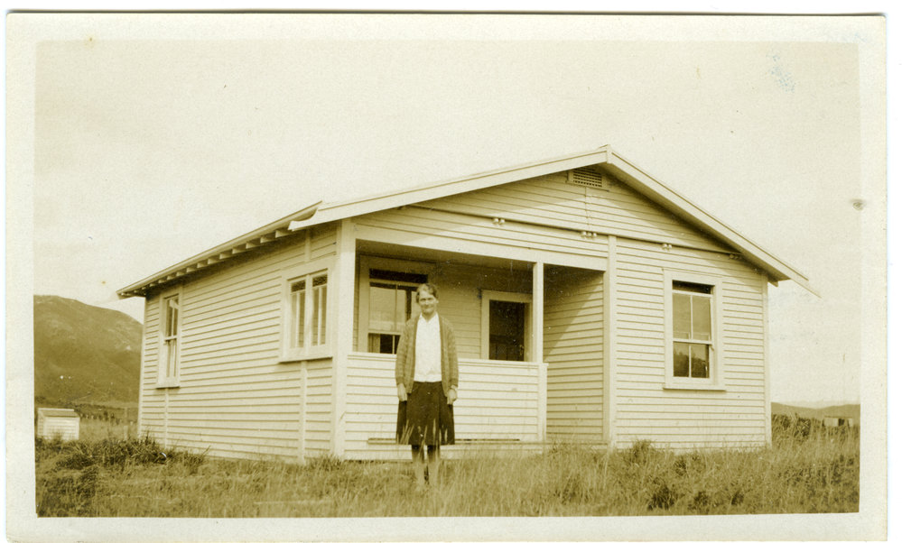 Sister Dorothy Keen (Mrs. Page) standing in front of wooden building
