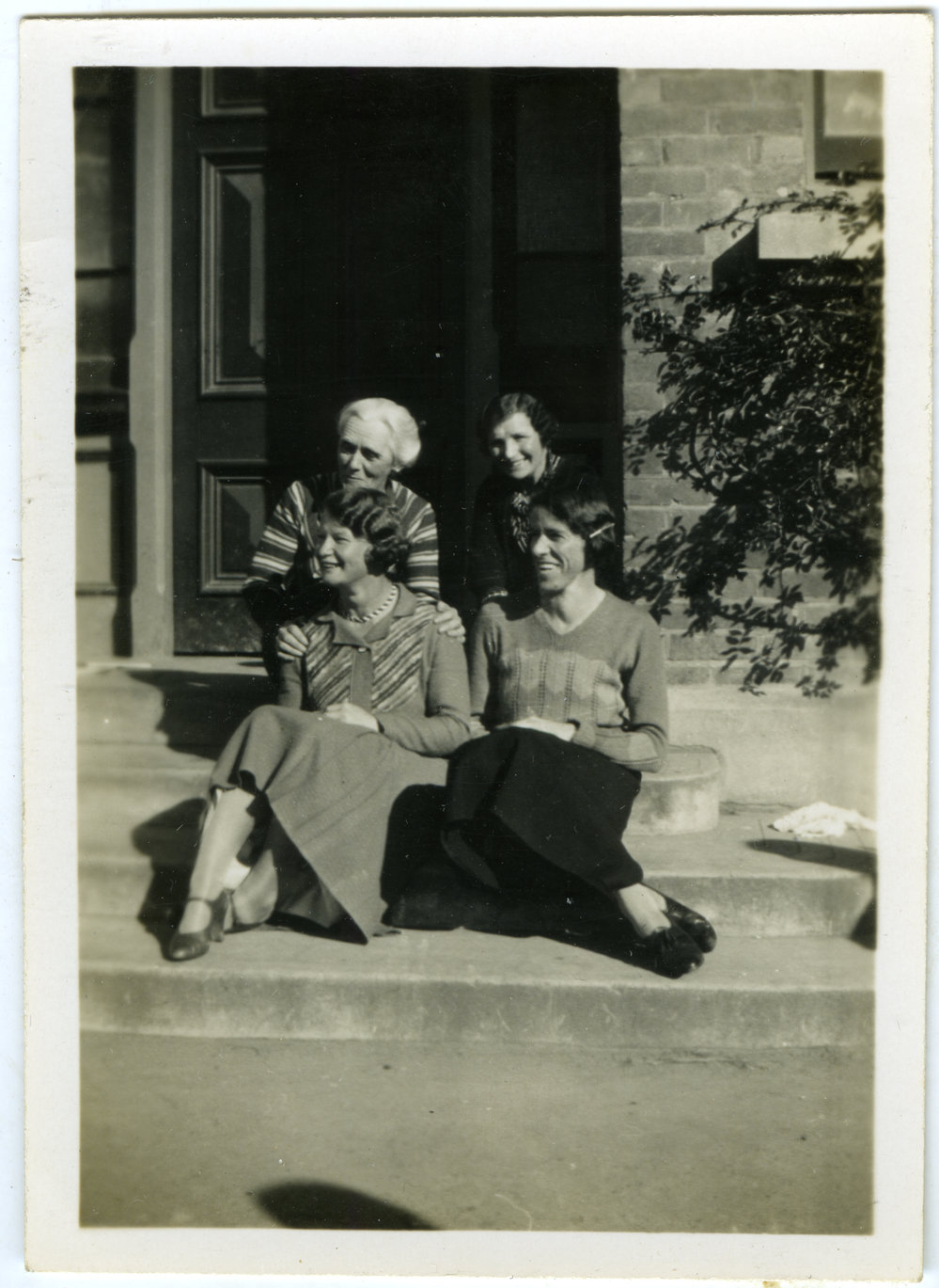 Deaconesses sit on stairs with Mrs. Scammell 