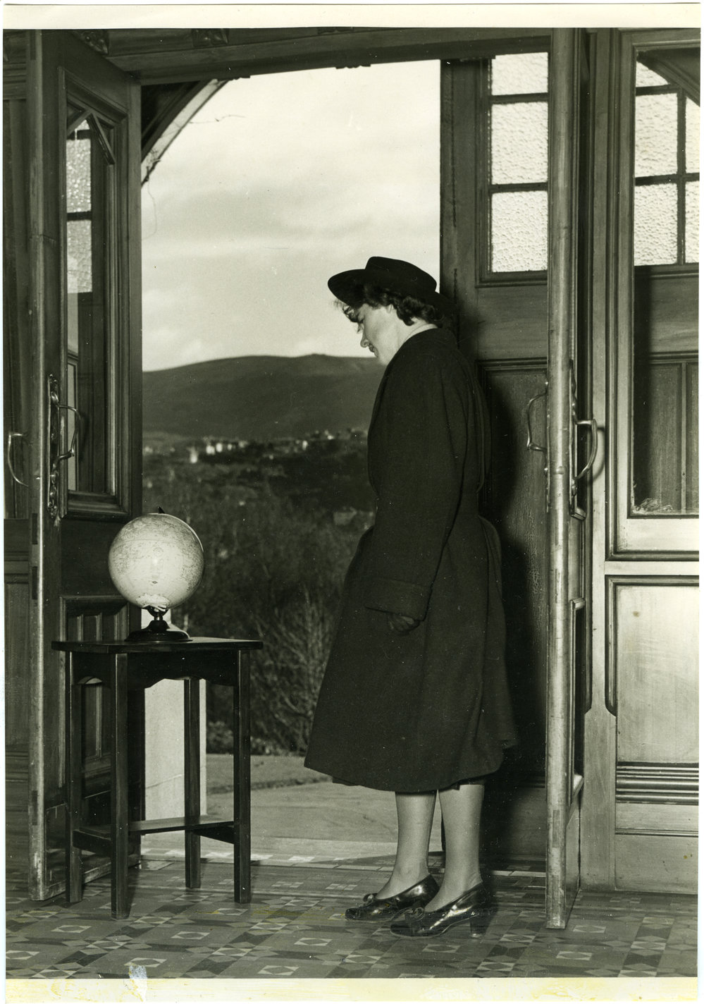 Deaconess standing at doorway with globe