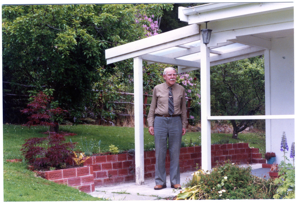 Unidentified man stands under a verandah