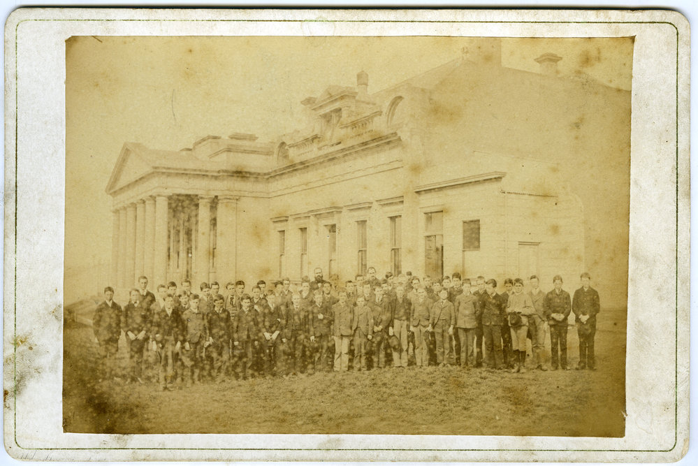Group of young students, including Alex Smith, standing in front of Otago Boys' High School