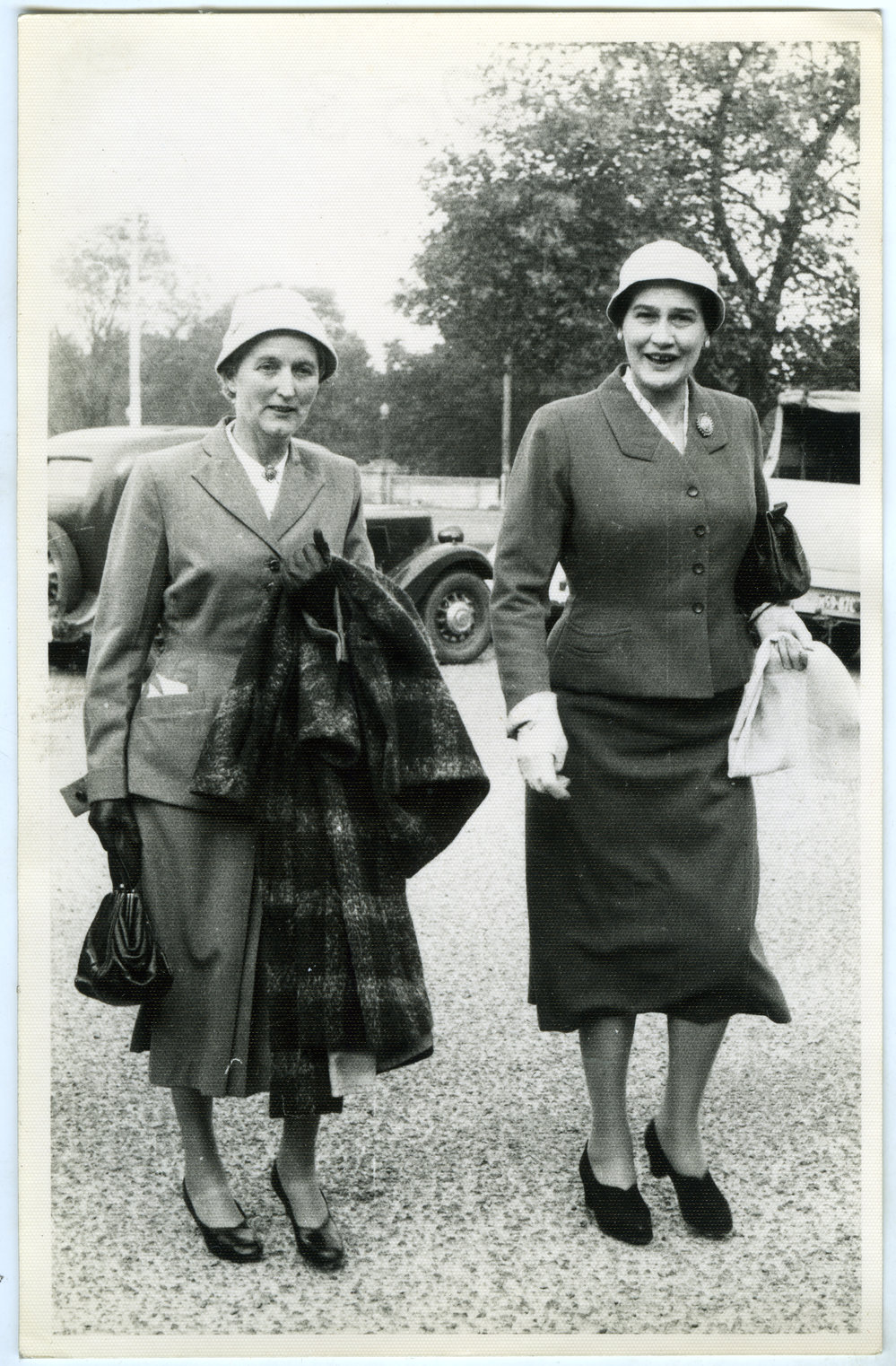 Two unidentified women wearing dress suits and hats