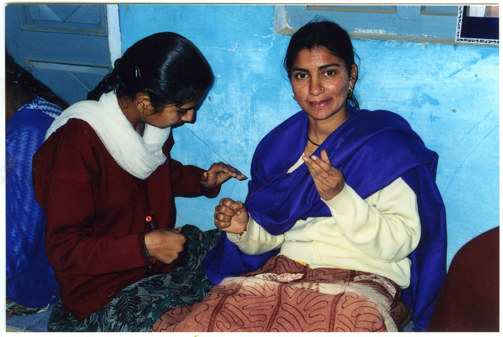 Two young women are learning the art of needlework