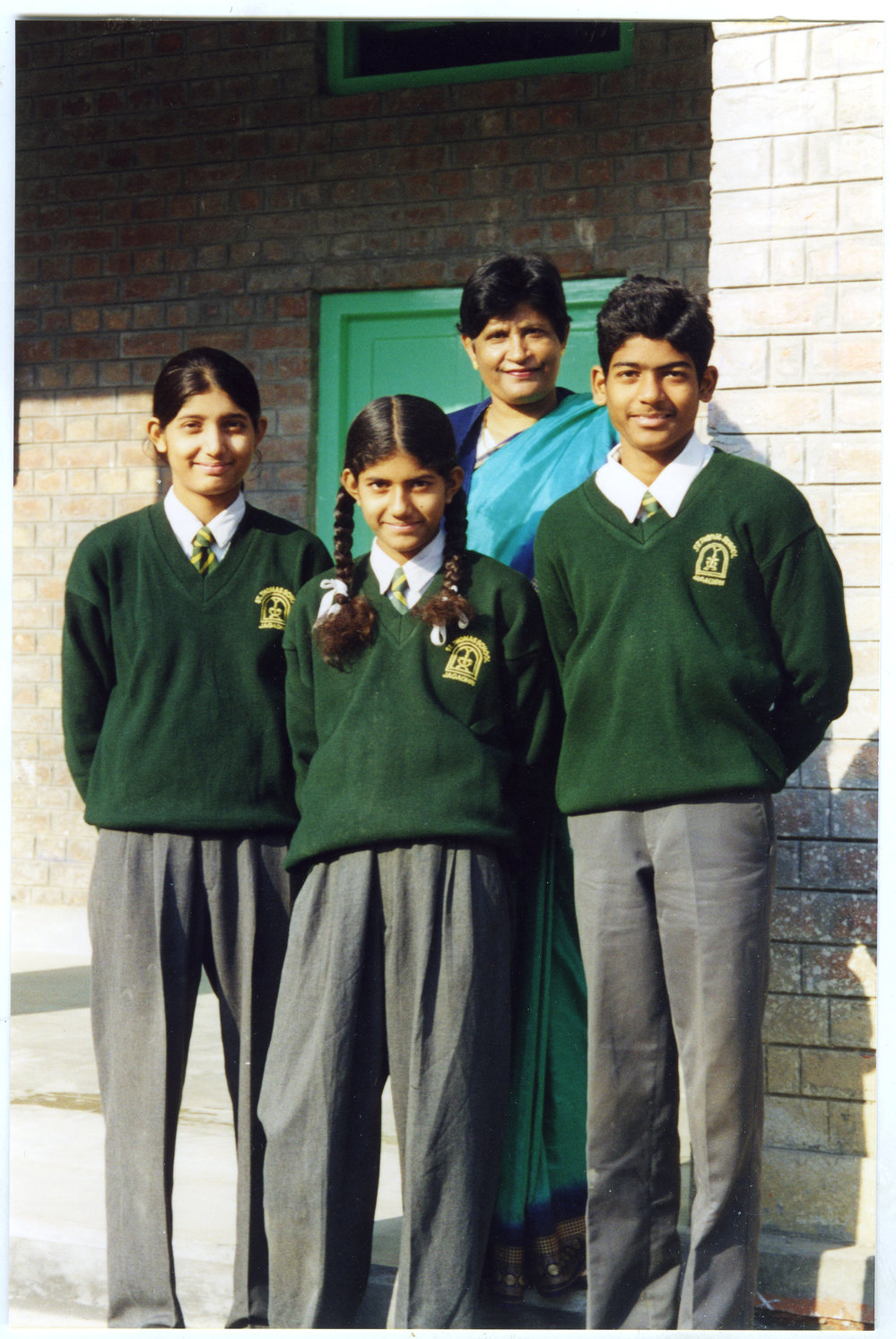 Three scholarship students for St.Thomas School, stand with Mrs. Singh
