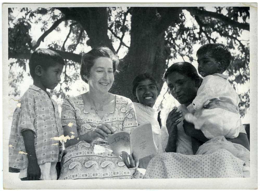 Doreen Riddell reading to Indian mother and children