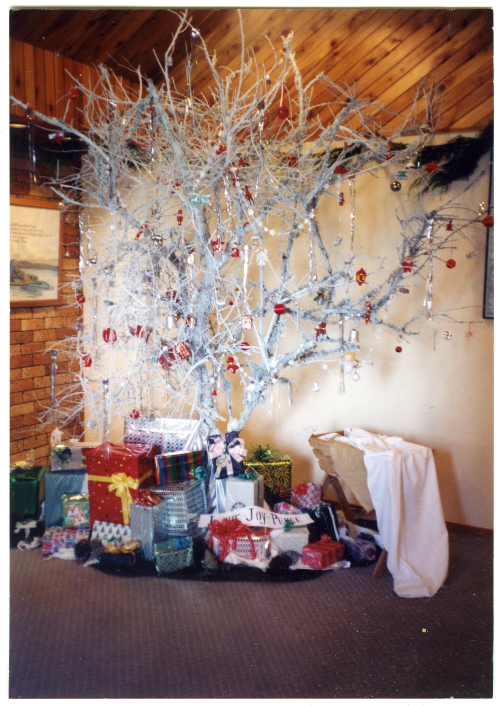 Silver Christmas tree, decorated with red baubles and presents