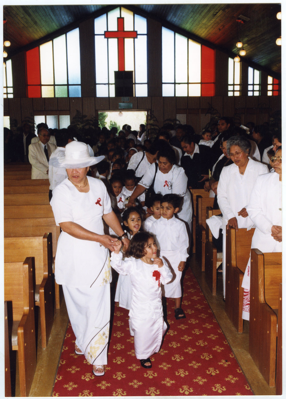 Children and women dressed in white walk down the aisle at Glen Eden Pacific Islanders Church during a White Sunday service, 2002 