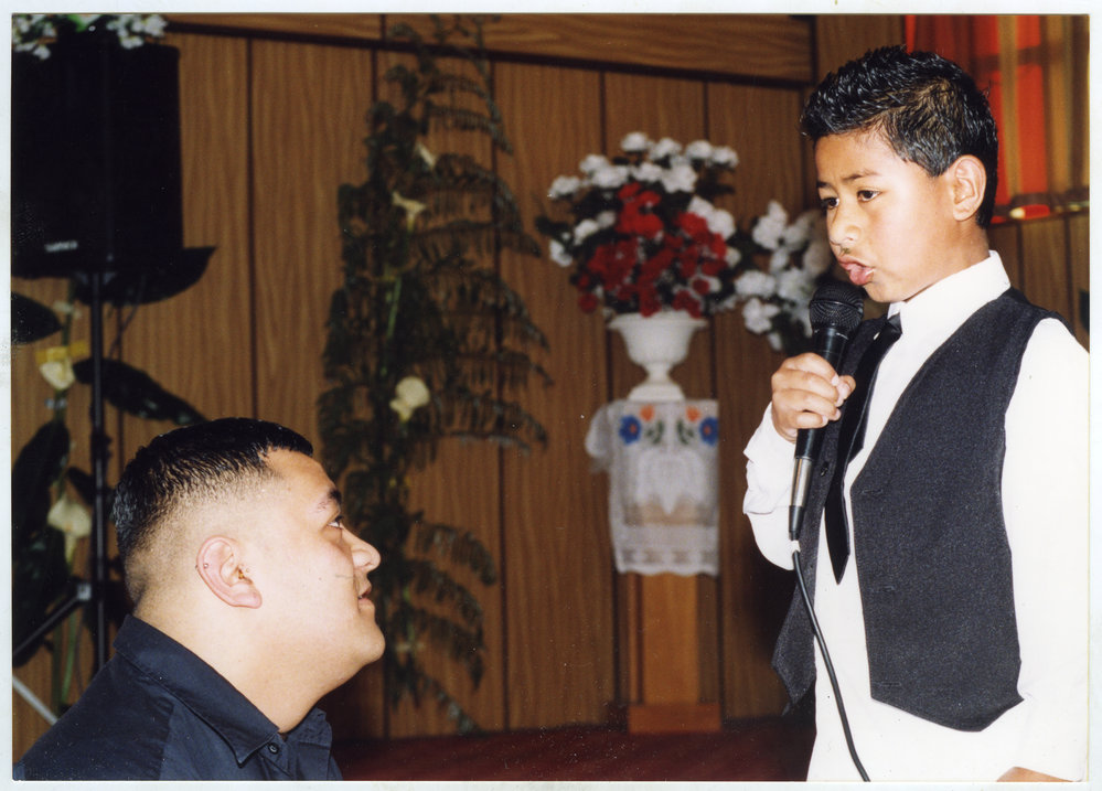 A young boy sings to an unidentified man at Glen Eden Pacific Islanders Church at a White Sunday service, 2002
