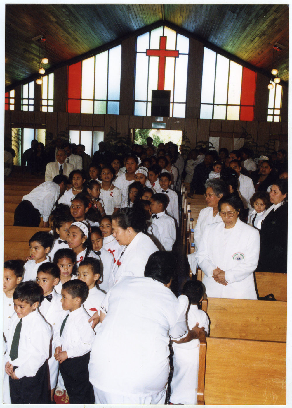 Children, men and women walk down the aisle at Glen Eden Pacific Islanders Church during White Service, 2002