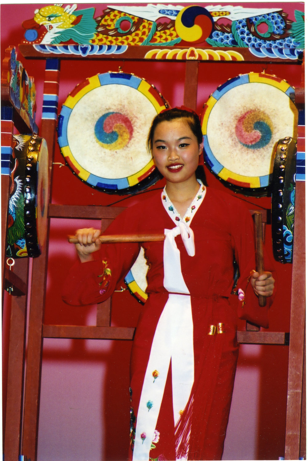 A young woman dressed in red plays traditional drums, General Assembly 2002
