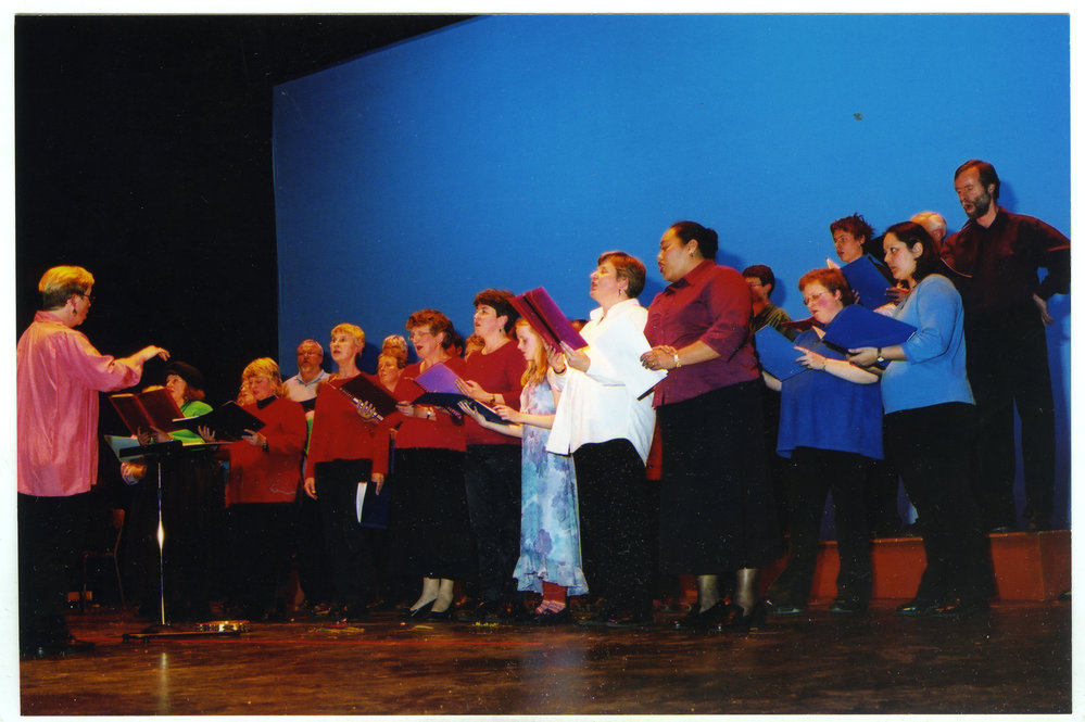 Unidentified group of men, women and children perform a song, General Assembly 2002