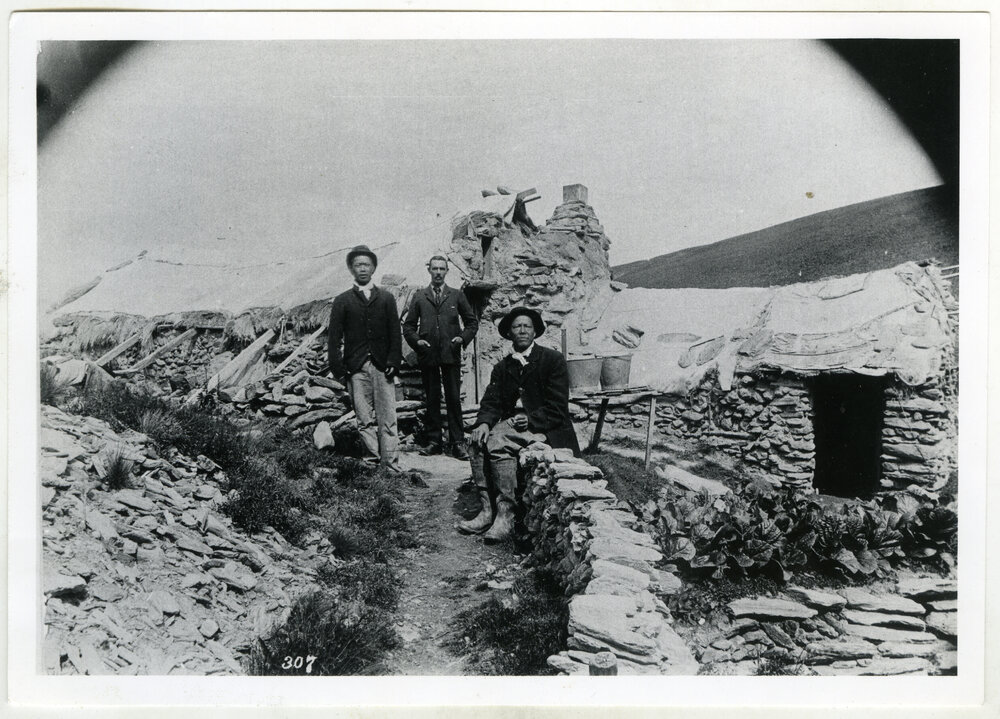 Reverend George McNeur and two Chinese men beside their rock dwelling, Potter's Gully