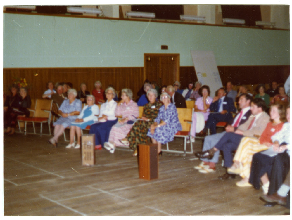 Seated parishioners fill a sports gymnasium, Cromwell Church