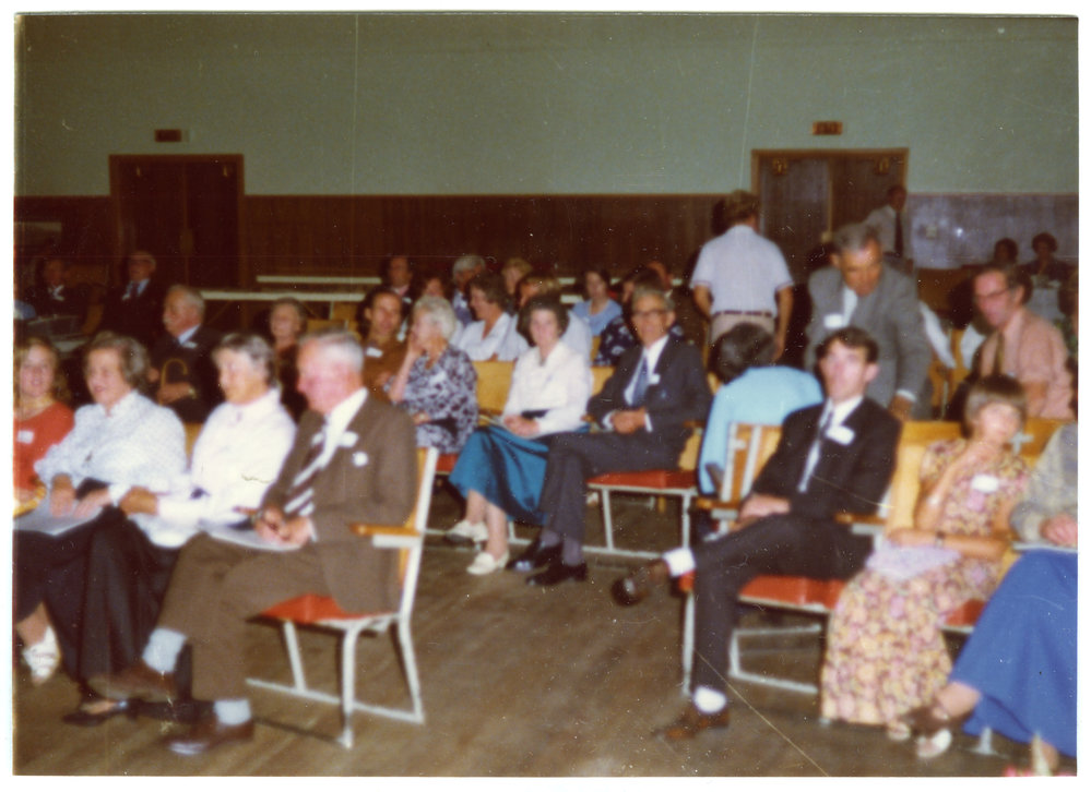 Seated parishioners fill a sports gymnasium, Cromwell Church