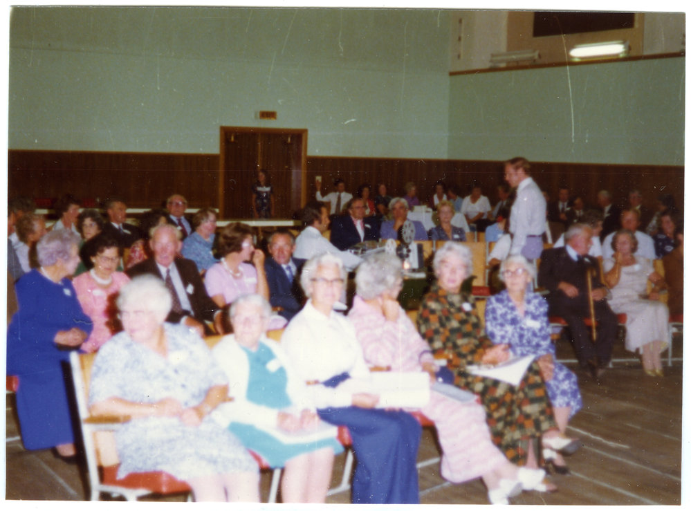 Seated parishioners fill a sports gymnasium, Cromwell Church