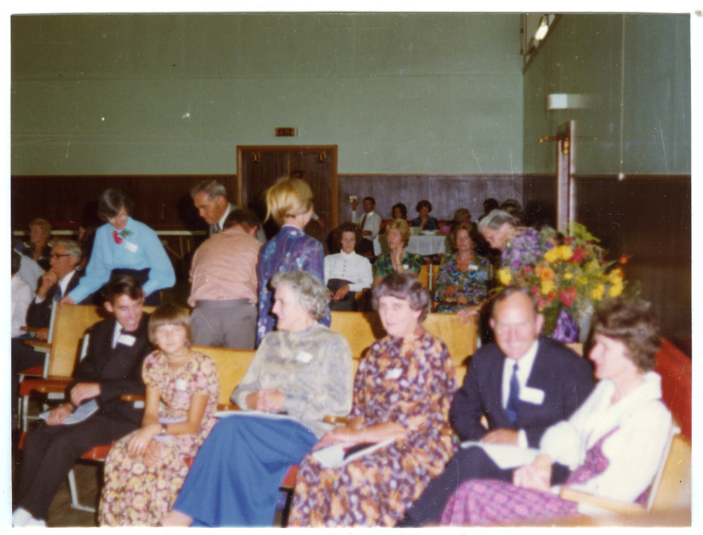 Seated parishioners fill a sports gymnasium, Cromwell Church
