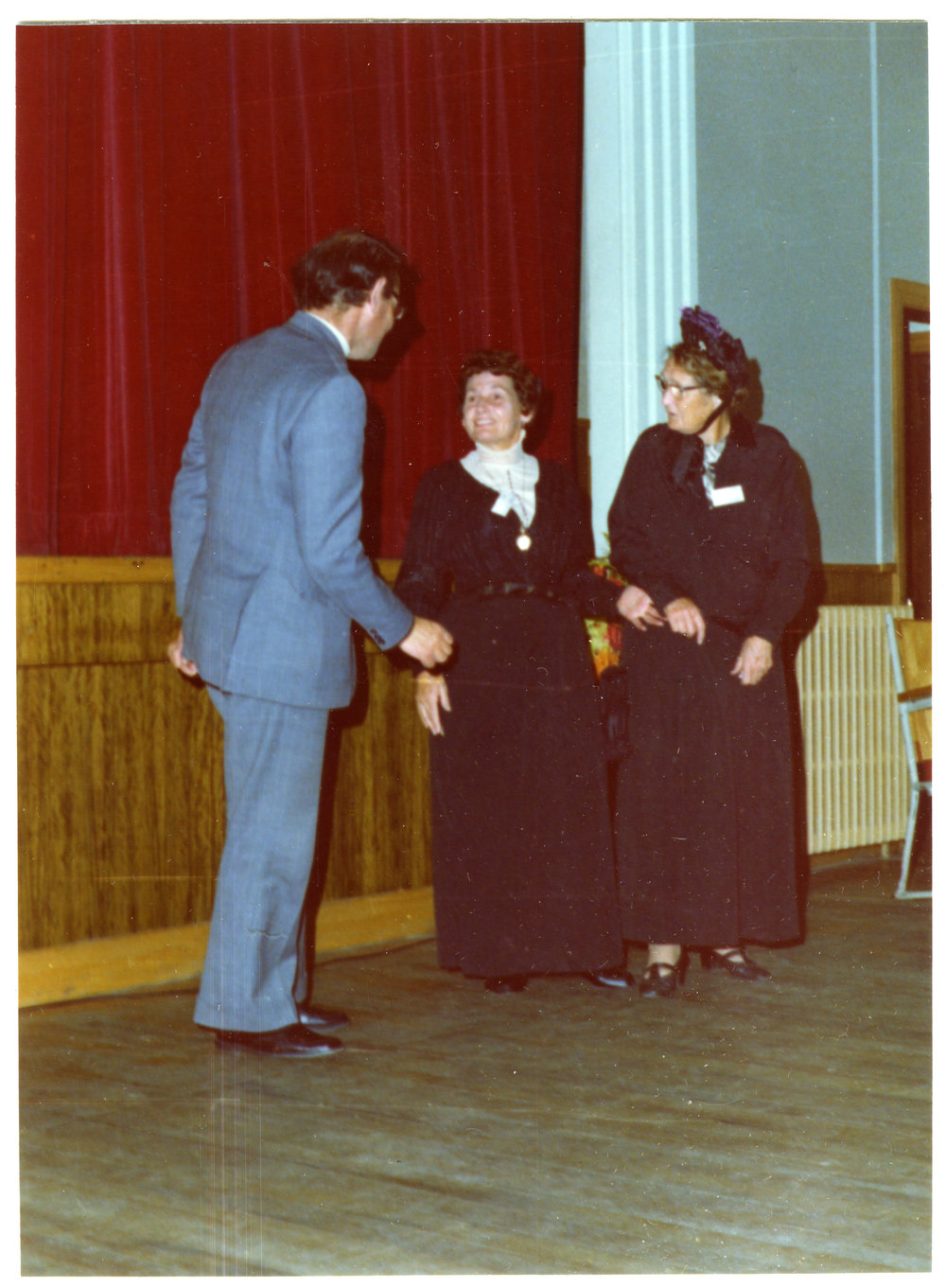 Two women in period clothing address a man in a grey suit, Cromwell Church