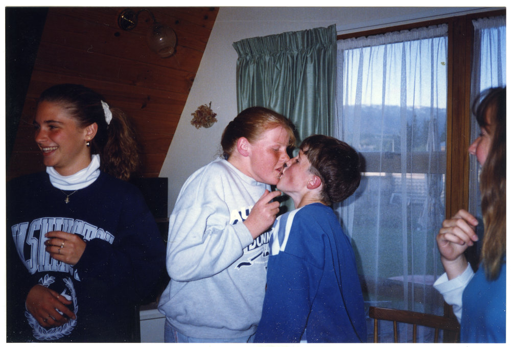 An unidentified girl and boy exchange a playing card, during a game. 