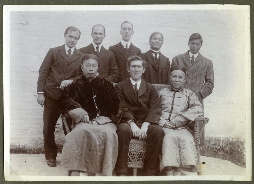 Doctor John Kirk and Doctor Edward Kirk sit among unidentified Chinese and European mean, 1910