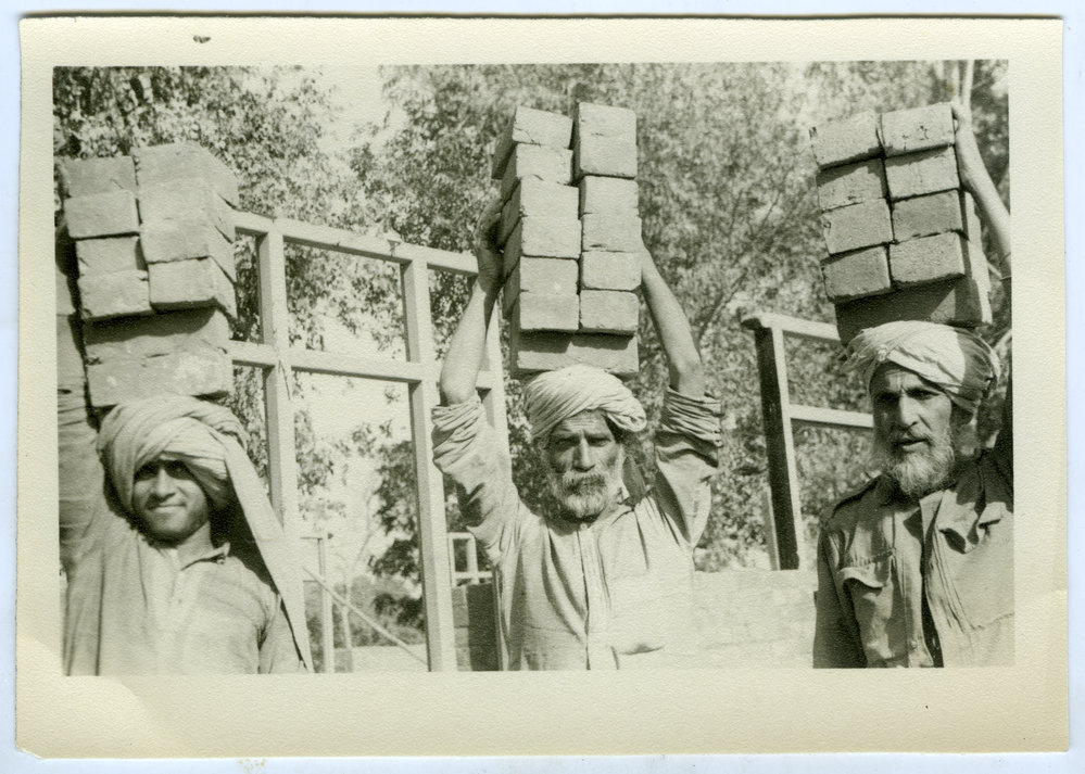 Workmen carrying bricks