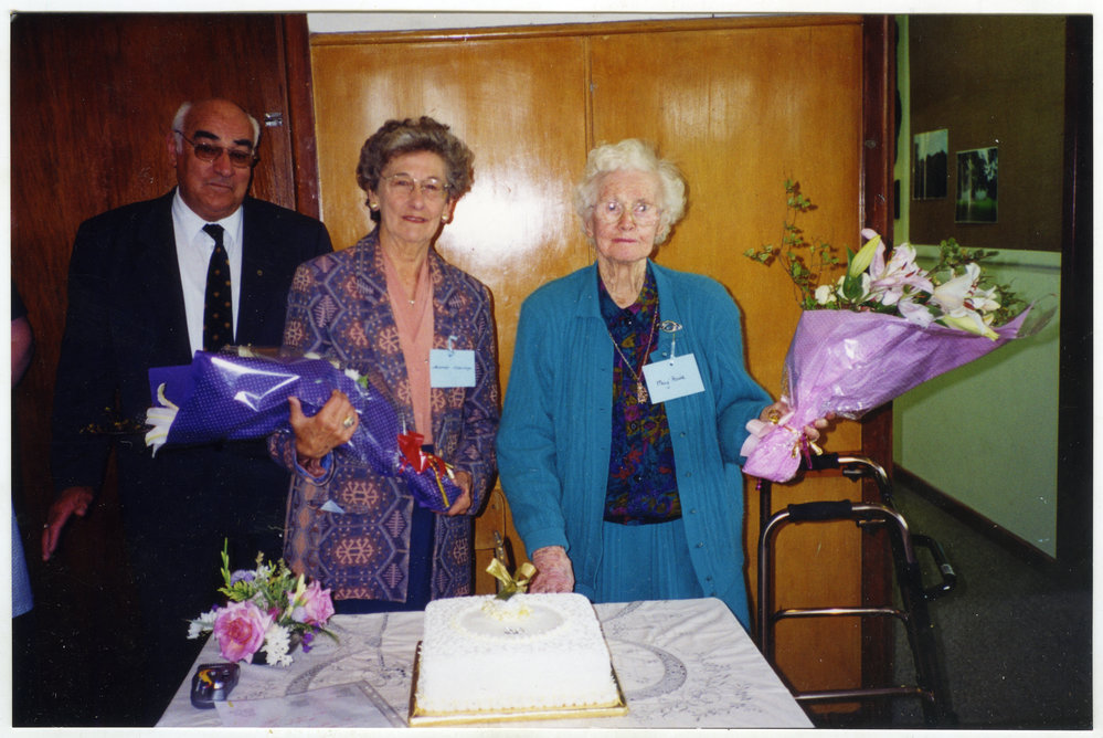Tom Campbell, Muriel Aldridge and May Howie are about to cut a cake, holding bouquets of flowers, St. Columba, Christchurch 