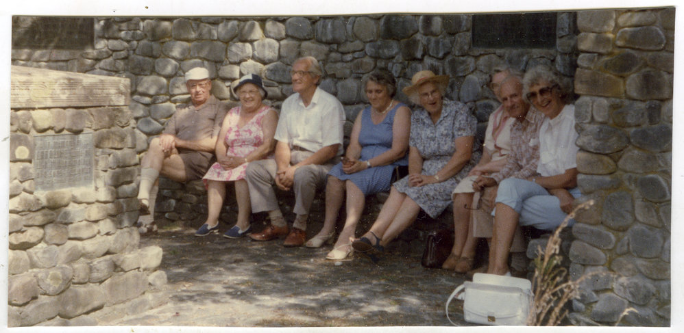 Unidentified women and men of St. Columba, are seated at the Memorial for Horses, Ford Milton Home, 1986