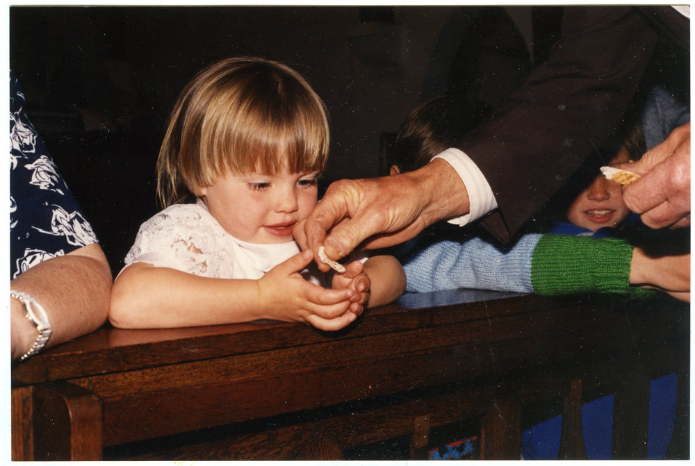 Unidentified young girl receiving the Communion wafer 