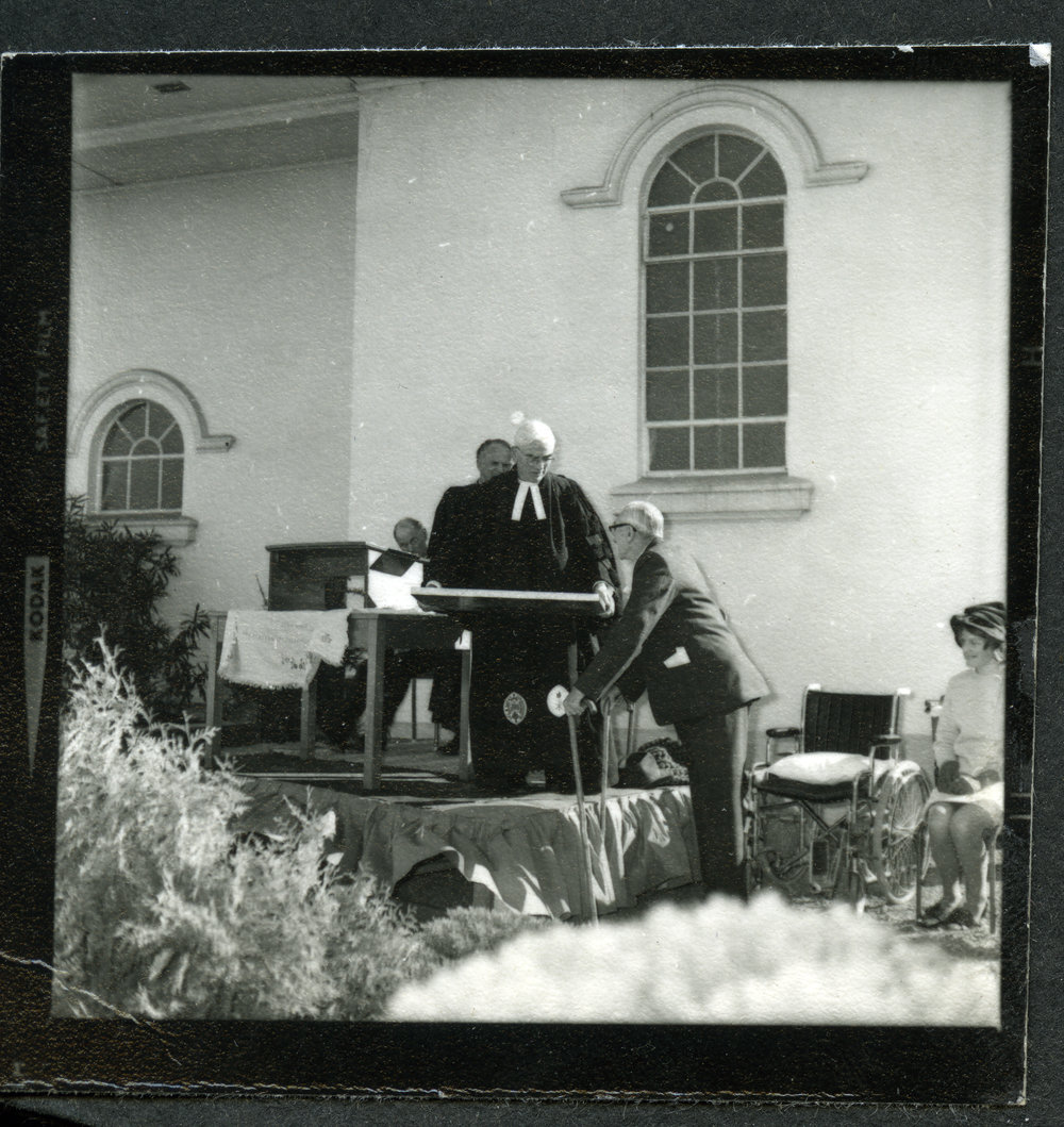 Unidentified man standing at a podium, talking to another unidentified man, John Knox, Rangiora, 1972