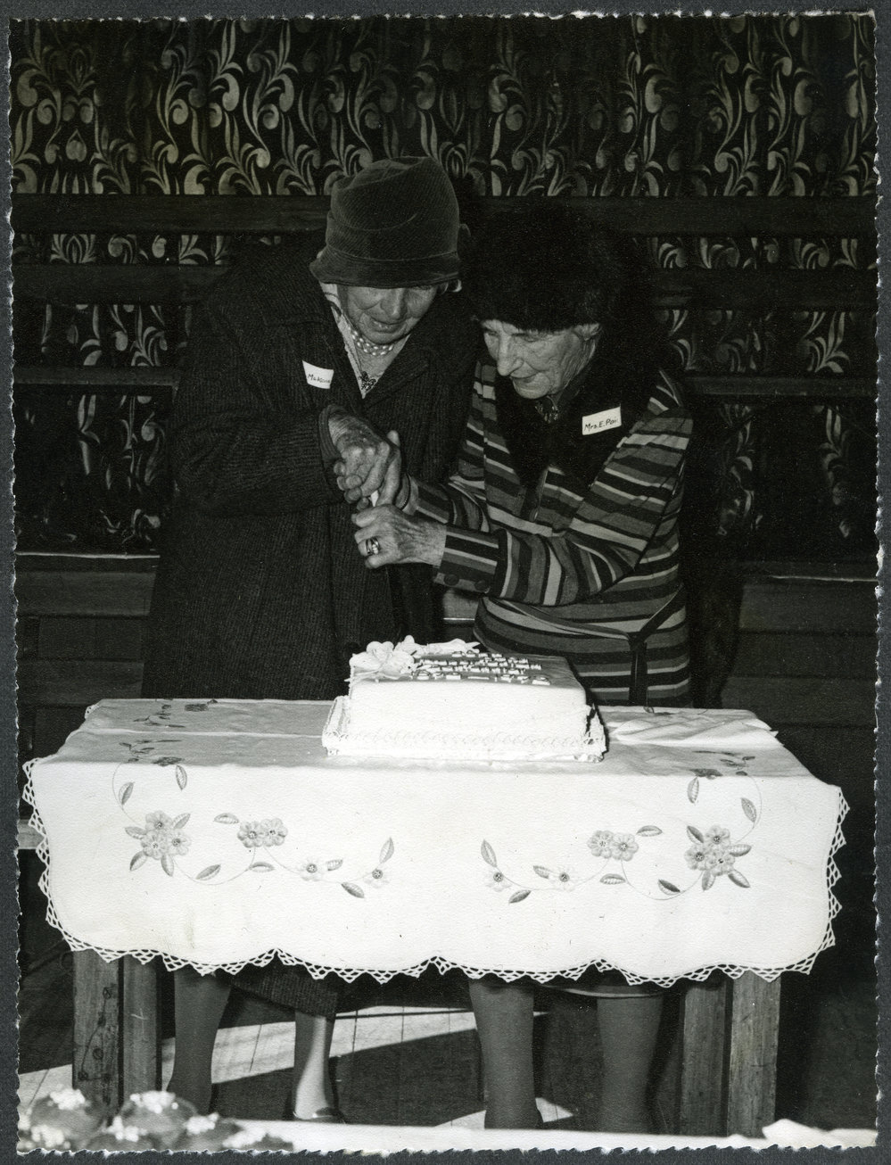 Two unidentified women cut the centenary cake, John Knox Church, Rangiora, 1972