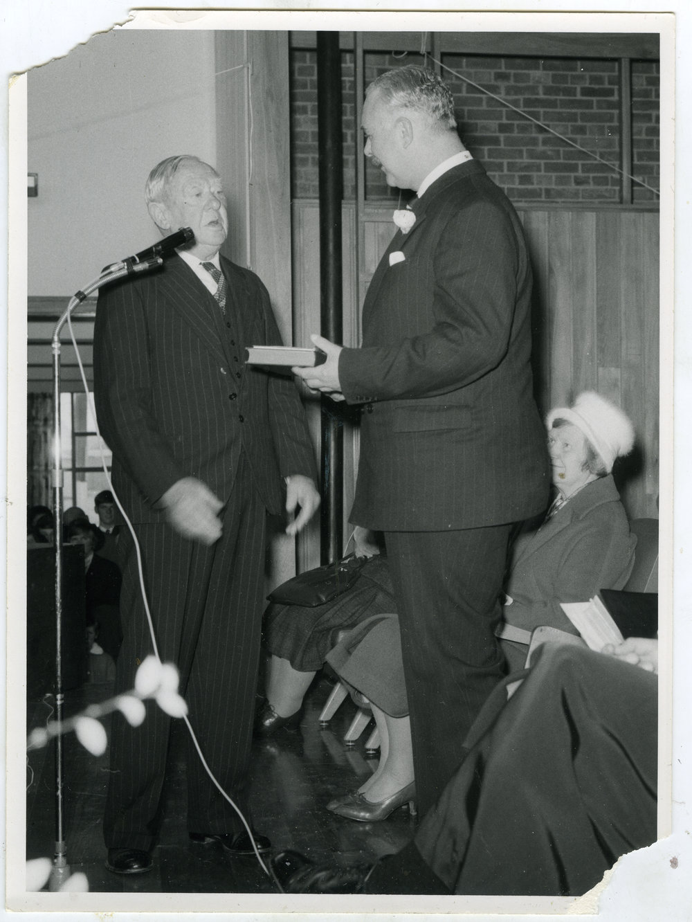 Bill Goss and unidentified man during a ceremony, with Elinor Wilson in the background