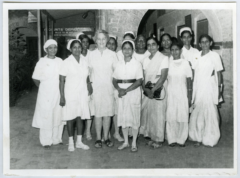 Beryl Howie stands outside the Christian Medical College and Hospital, with unidentified Indian nurses