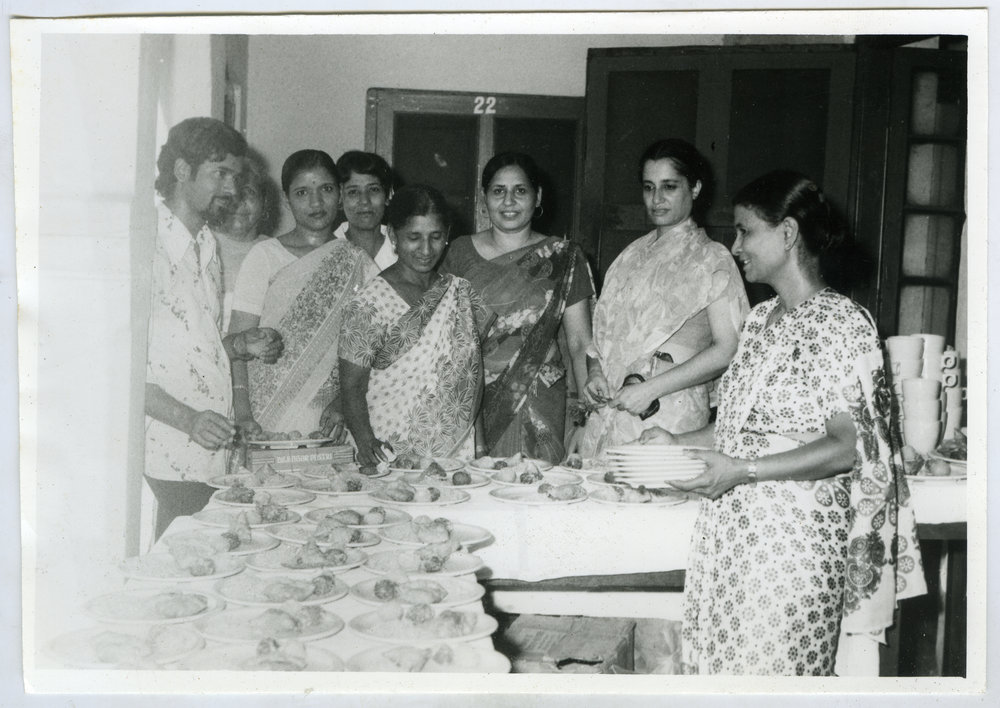 Unidentified women dressed in saris serve a meal
