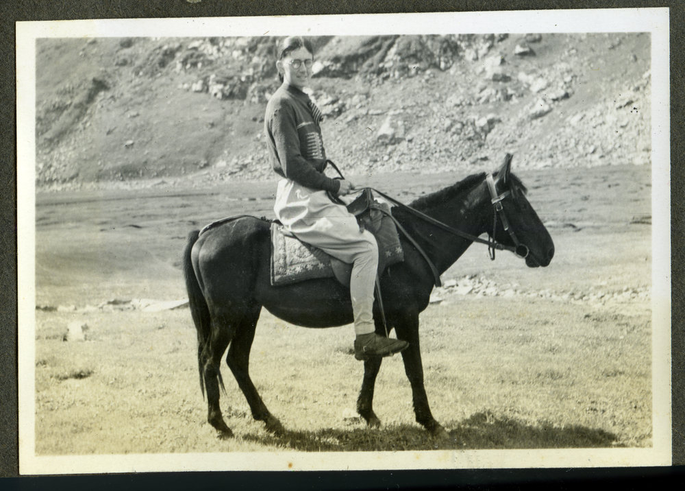 Lorraine E. Saunders riding a mule, India
