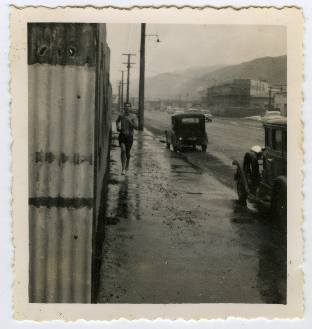 "Don Vautier arrives at Petone in pouring rain," Masterton Relay, 1955, Presbyterian Harrier Club - Wellington