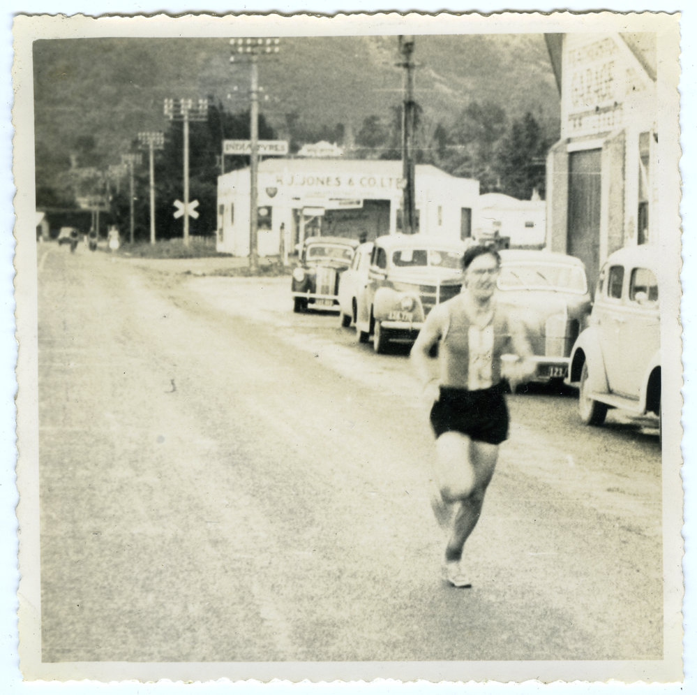 "Ian Ruffell smiling (or grimacing) as he enters Featherstone, Masterton Relay," Presbyterian Harrier Club - Wellington