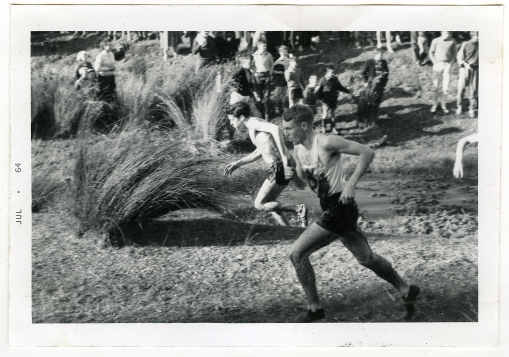 "Lyn Jones (8th) leading the field out of the first bog, in the junior race," 1964 Dorne Cup at Trentham, Presbyterian Harrier Club - Wellington