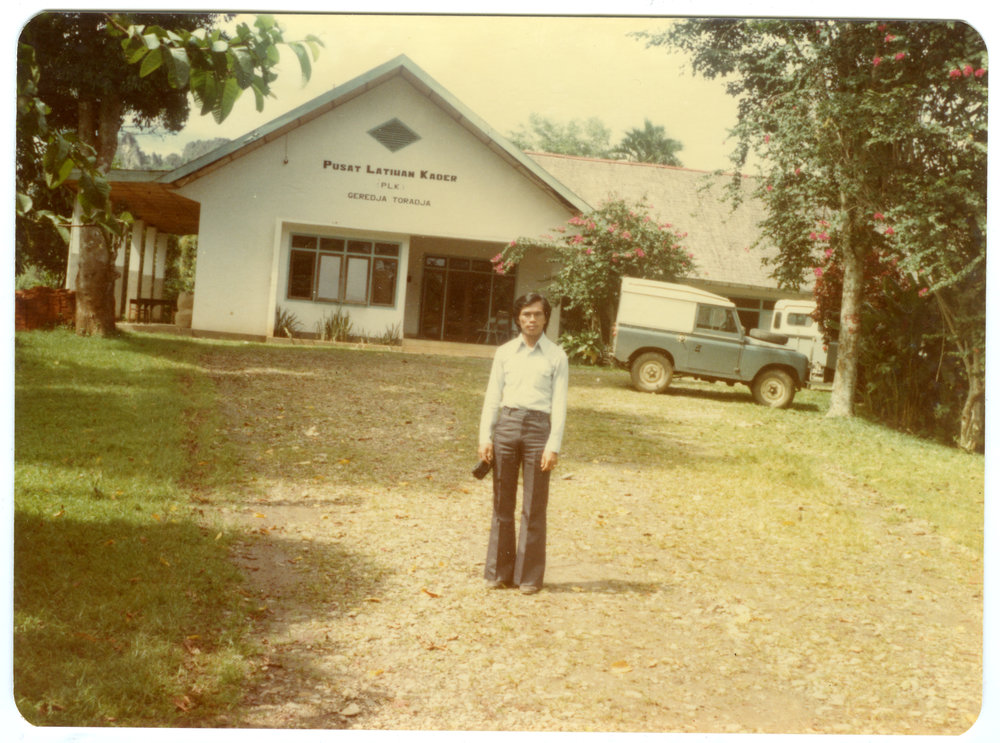Johanes Rante Banu in Front of the Main Hall at Tangmentoe