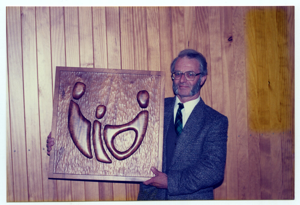 Rev. Bill Wallace holding a wooden artwork