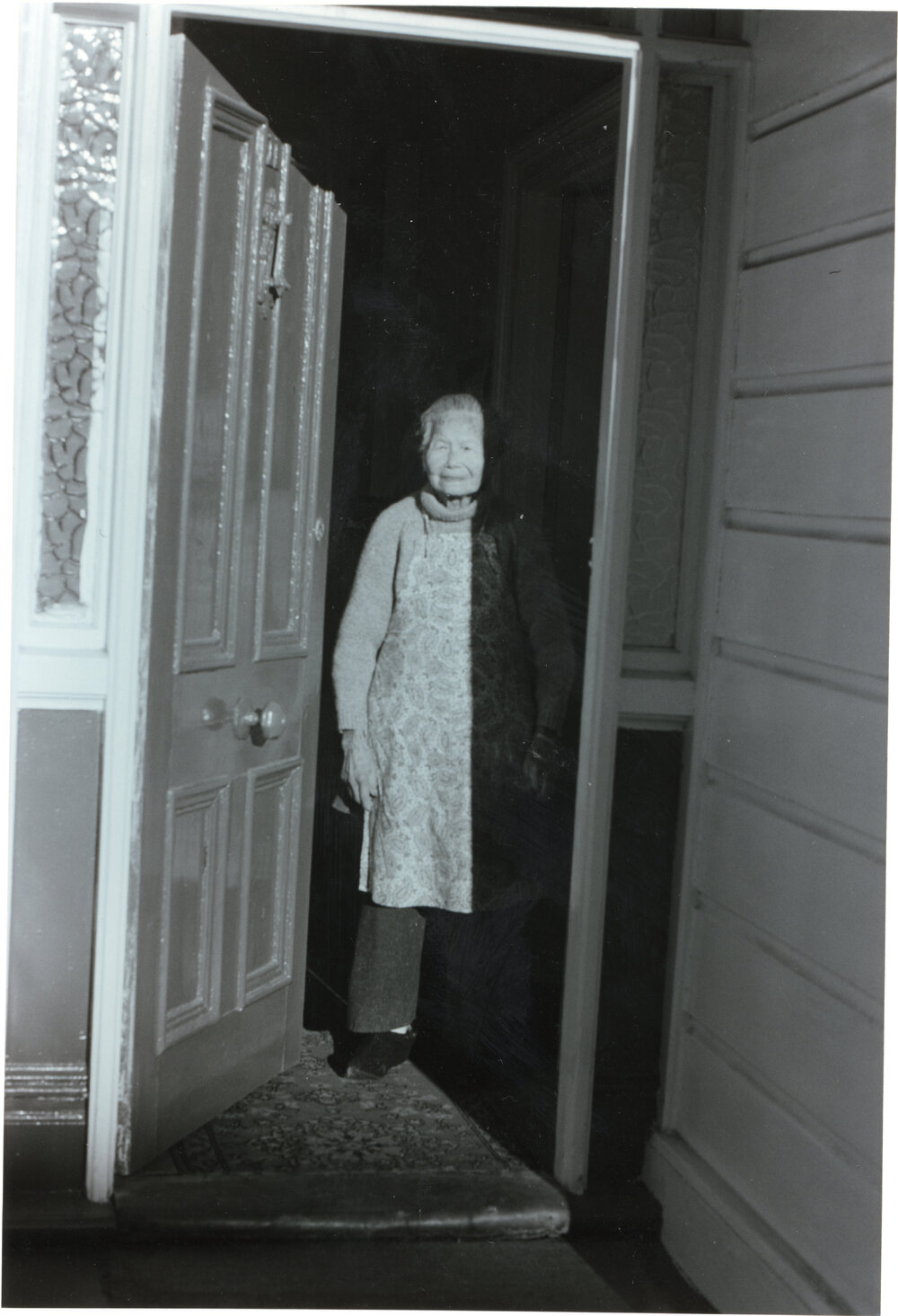 Mrs Gin at doorway of her home