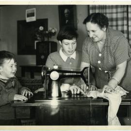 Matron Mrs. E. Mclean helping residents of Cameron Cottage, Glendining Home, sew, 1955