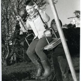 Two unknown girls from Glendining Home playing on the swings, 1968