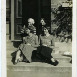 Deaconesses sit on stairs with Mrs. Scammell 