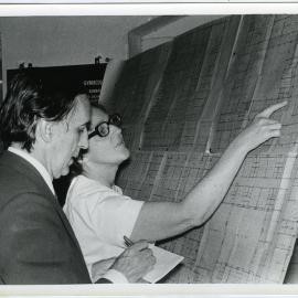 Mr. Cunninghame, High Commissioner for New Zealand making notes while Dr. Beryl Howie explaining the plans of New Obstetrics and Gynaecology Building