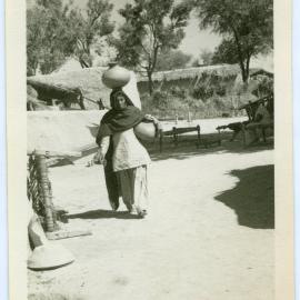 Unidentified village women carrying water