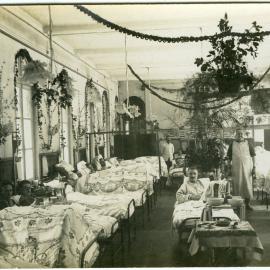 A hospital ward decorated for Christmas, with soldiers in bed 