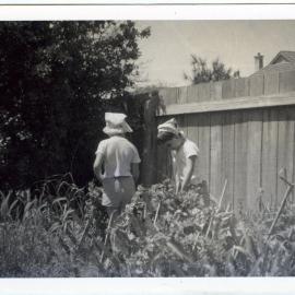 Two children are playing in a garden