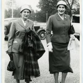 Two unidentified women wearing dress suits and hats